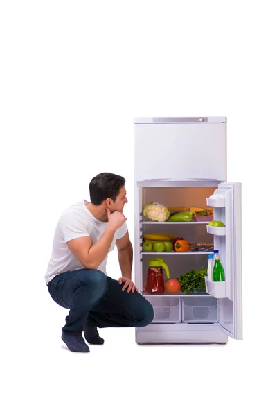 Uomo vicino al frigo pieno di cibo — Foto Stock
