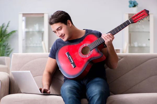 Junger Mann übt zu Hause das Gitarrespielen — Stockfoto