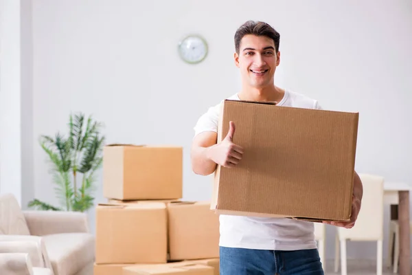 Jeune homme déménageant des boîtes à la maison — Photo