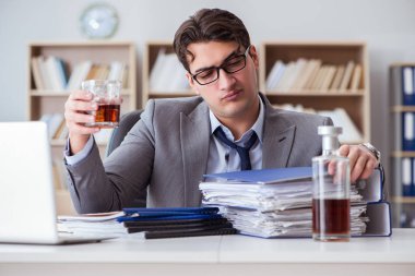 İş adamı ofiste içiyor.