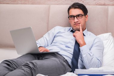 İş adamı evdeki yatakta çalışıyor.