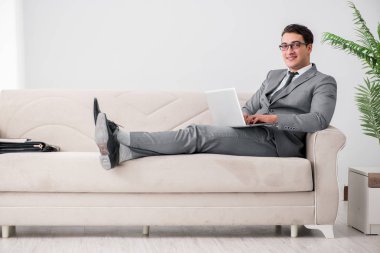 Genç işadamı kanepede yatıyor.