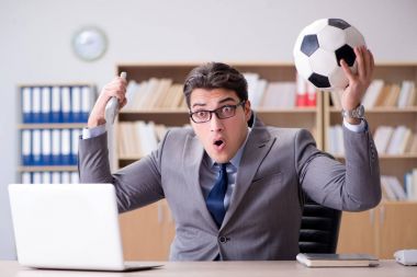 Businessman with football ball in office clipart