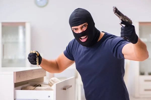 Ladrão usando balaclava roubando coisas valiosas — Fotografia de Stock