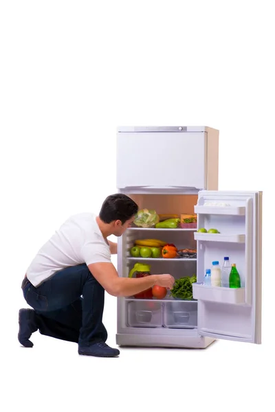 Homem ao lado do frigorífico cheio de comida — Fotografia de Stock