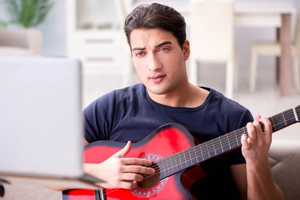 Joven practicando la guitarra en casa — Foto de Stock