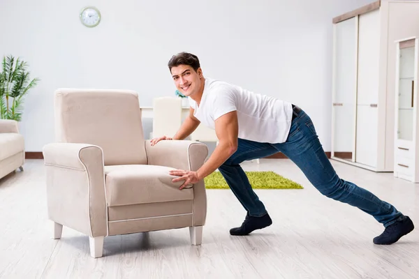 Hombre joven moviendo muebles en casa — Foto de Stock