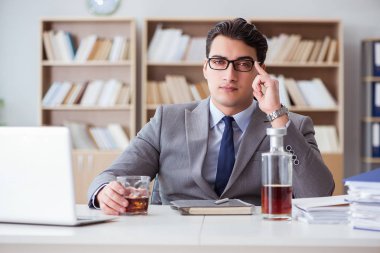 İş adamı ofiste içiyor.
