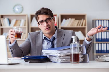 İş adamı ofiste içiyor.