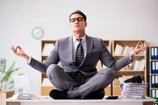 Young businessman meditating in the office — Stock Photo, Image