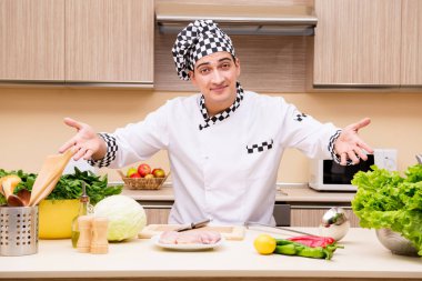 Genç aşçı mutfakta çalışıyor.