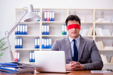 Ofiste masasında oturan gözü bağlı iş adamı.