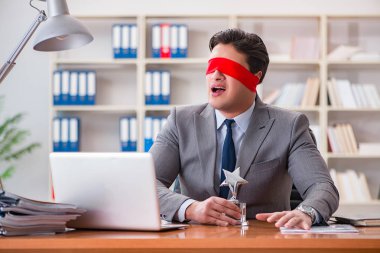 Ofiste masasında oturan gözü bağlı iş adamı.