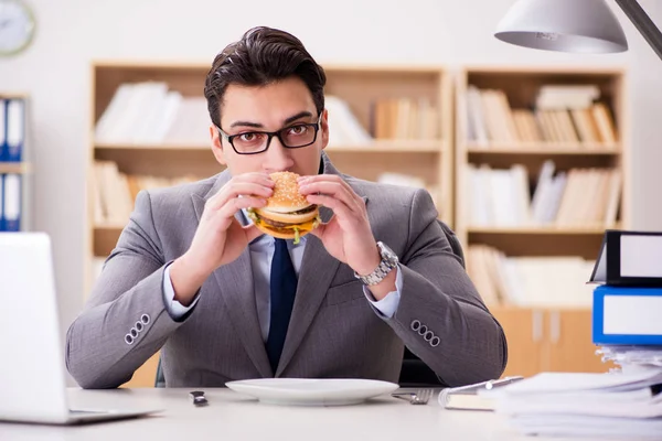 Hungriger, lustiger Geschäftsmann isst Junkfood-Sandwich — Stockfoto