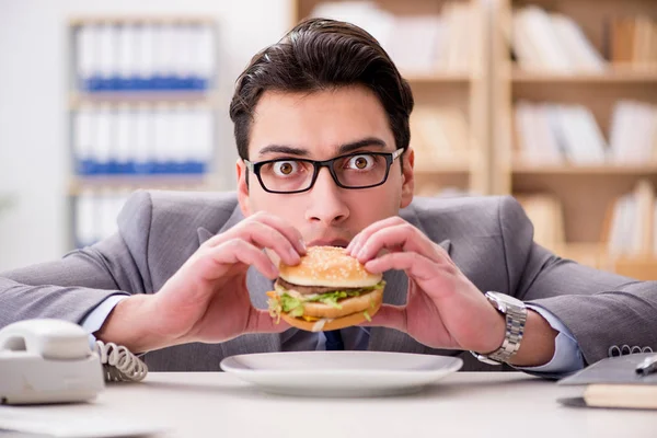 Hungriger, lustiger Geschäftsmann isst Junkfood-Sandwich — Stockfoto