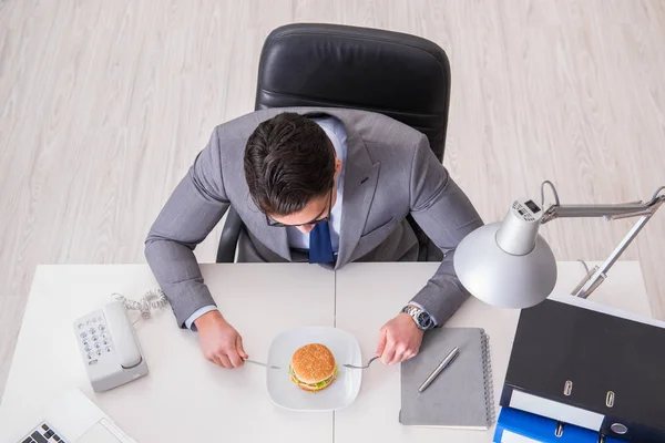 Hongerige grappige zakenman die junk food sandwich eet — Stockfoto