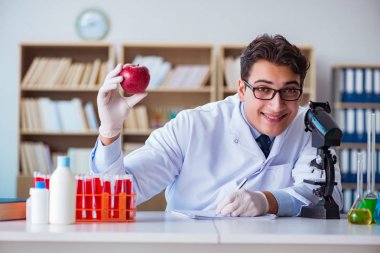 Bilim adamı organik meyve ve sebzeler üzerinde çalışıyor.