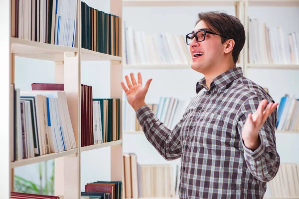 Jovem estudante procurando livros na biblioteca da faculdade — Fotografia de Stock