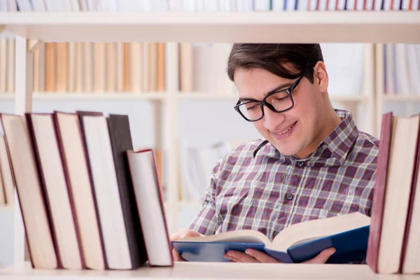Jonge student op zoek naar boeken in universiteitsbibliotheek — Stockfoto
