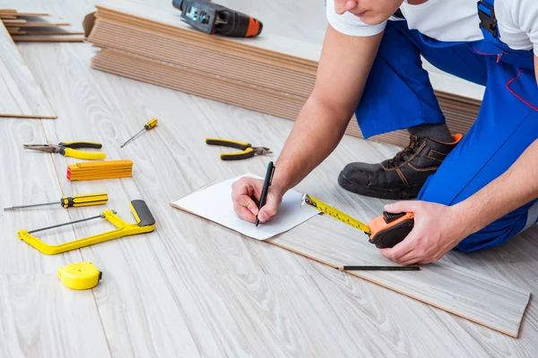 Reparador que estabelece piso laminado em casa — Fotografia de Stock