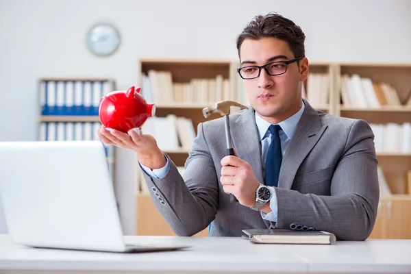 Uomo d'affari che rompe il salvadanaio in ufficio — Foto Stock