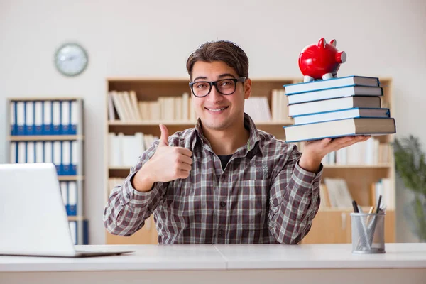 Mladý student lámání prasátko banka koupit učebnice — Stock fotografie