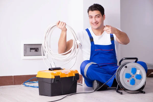 Mladý elektrikář pracující na zásuvce doma — Stock fotografie