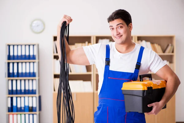 Jonge elektricien met kabel aan het werk — Stockfoto