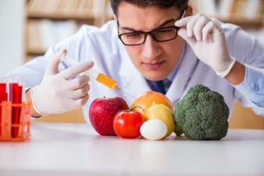 Erkek doktor meyve ve sebzeleri kontrol ediyor.