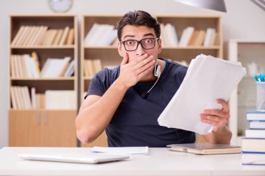 Kütüphanede evrakları olan korkmuş bir öğrenci.