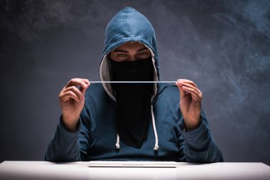 Bilgisayar korsanı karanlık odada çalışıyor.