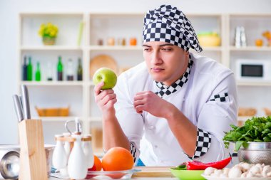 Genç aşçı mutfakta çalışıyor.