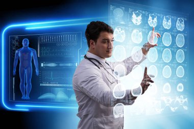 Erkek doktor MRI taramasının röntgenini çekiyor.
