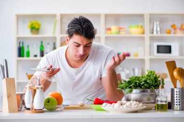 Genç aşçı mutfakta çalışıyor.