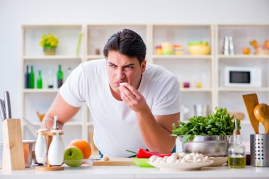 Genç aşçı mutfakta çalışıyor.