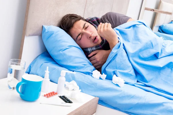 Больной человек с гриппом лежит в постели — стоковое фото