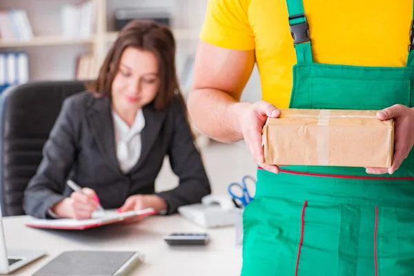 Postbode bezorgt pakketje op kantoor — Stockfoto