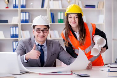 İnşaat ustabaşı çizimleri gözden geçiriyor