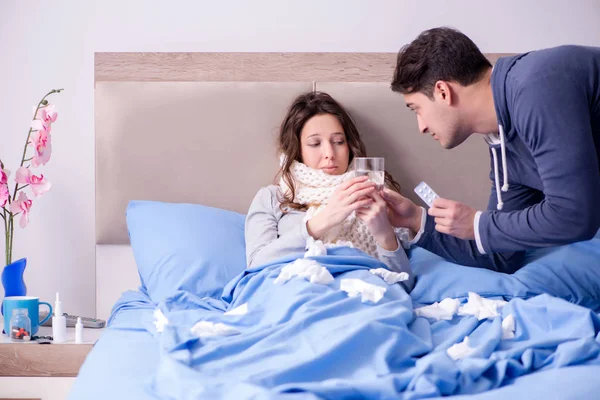 Vrouw die zorgt voor zieke man thuis in bed — Stockfoto