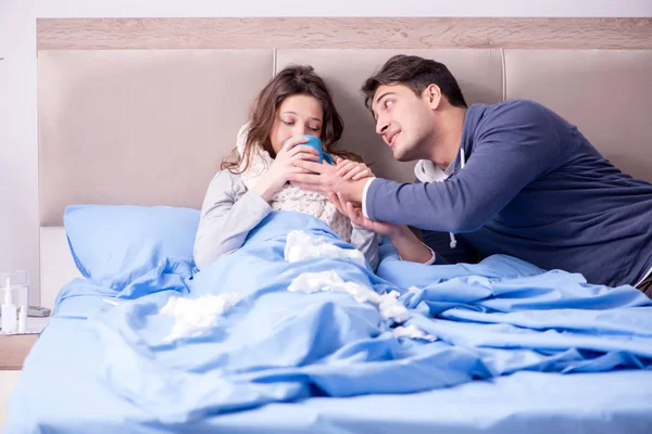 Жена ухаживает за больным мужем дома в постели — стоковое фото