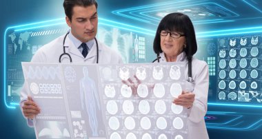 Kadın ve erkek doktor MRI görüntülerine bakıyor.