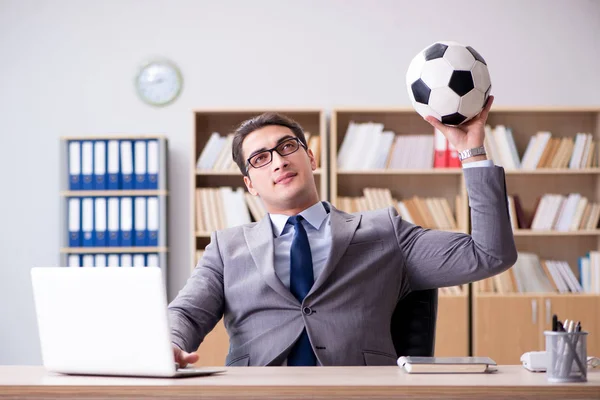 Бизнесмен с футбольным мячом в офисе — стоковое фото