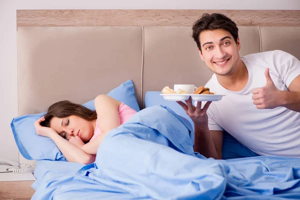 Família feliz tomando café da manhã na cama — Fotografia de Stock