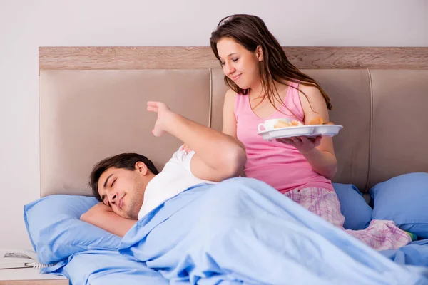 Lycklig familj som äter frukost på sängen — Stockfoto