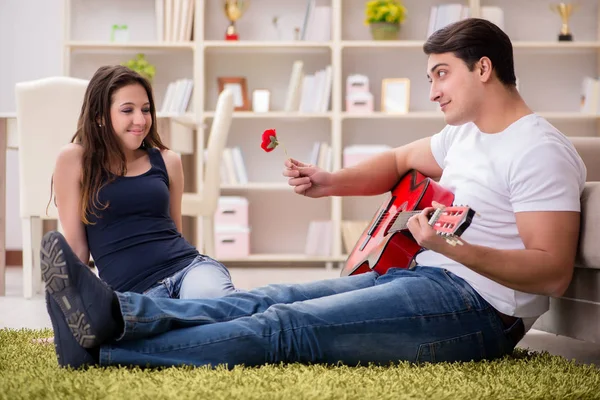 Романтическая пара, играющая на гитаре на полу — стоковое фото