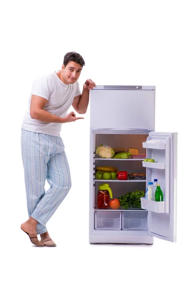 Homem ao lado do frigorífico cheio de comida — Fotografia de Stock