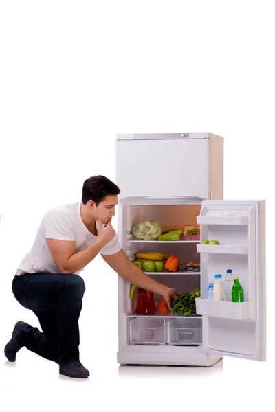 Человек рядом с холодильником полный еды — стоковое фото
