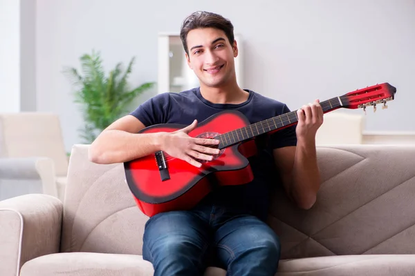 Giovane uomo che pratica la chitarra a casa — Foto Stock