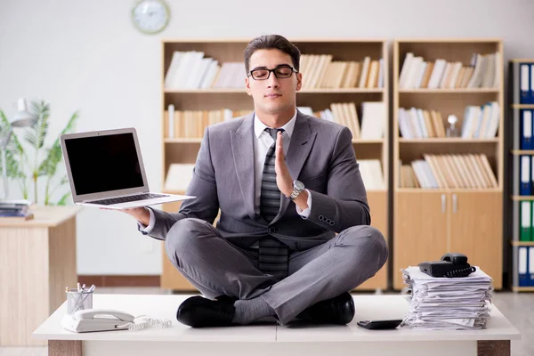 Young businessman meditating in the office — Stock Photo, Image