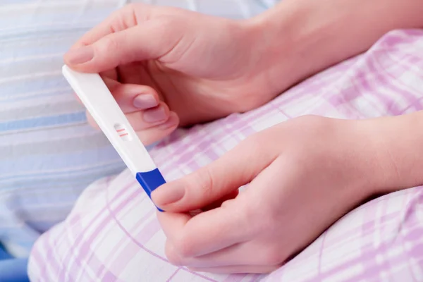 Mujer descubriendo su prueba de embarazo positiva —  Fotos de Stock